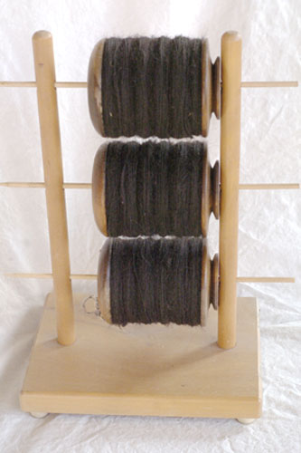 Three bobbins full of black alpaca